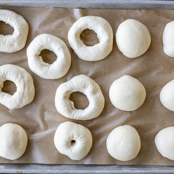Bagels shaped on a baking sheet.