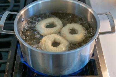 Boiling bagels in a pot.