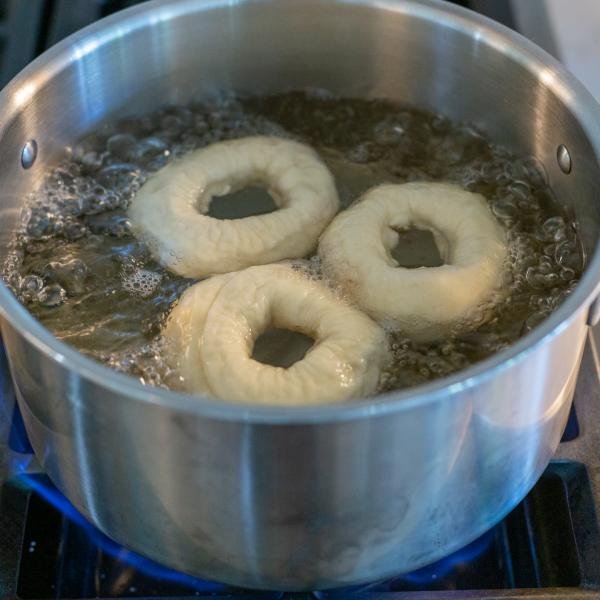 Boiling bagels in a pot.