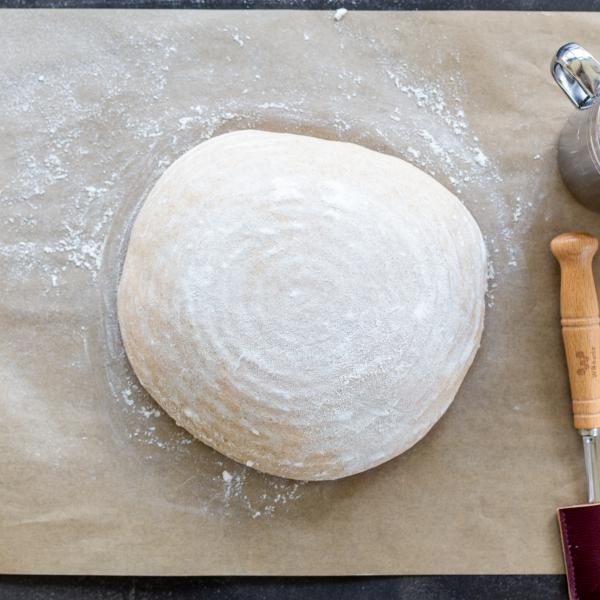Shaped wheat sourdough bread on a parchment paper.