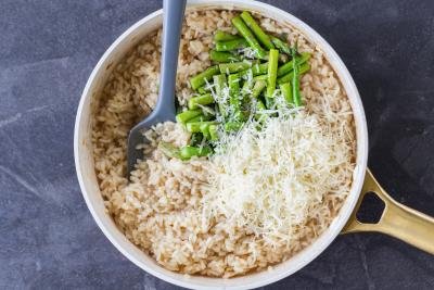 Parmesan cheese in a pan with rice and asparagus.