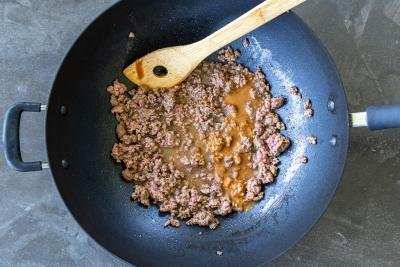 Ground beef with sauce cooking in a wok.