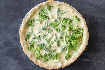 Unbaked Broccoli Quiche in a pan.