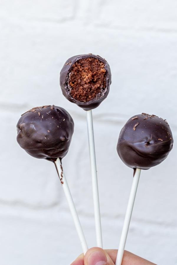 Three Chocolate Cake Pops in a hand.