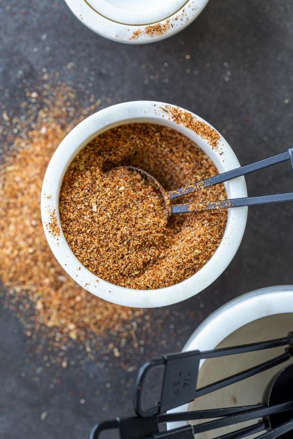 Fajita seasoning in a bowl with a measuring spoon.