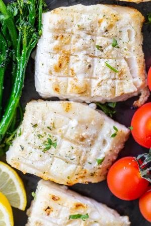 Grilled cod on a pan with veggies.