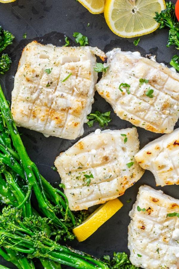 Grilled cod on a pan with veggies.