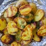Grilled potatoes on foil with dill.