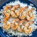 Grilled shrimp on a plate with rice.