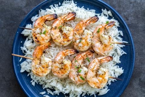 Grilled shrimp on a plate with rice.