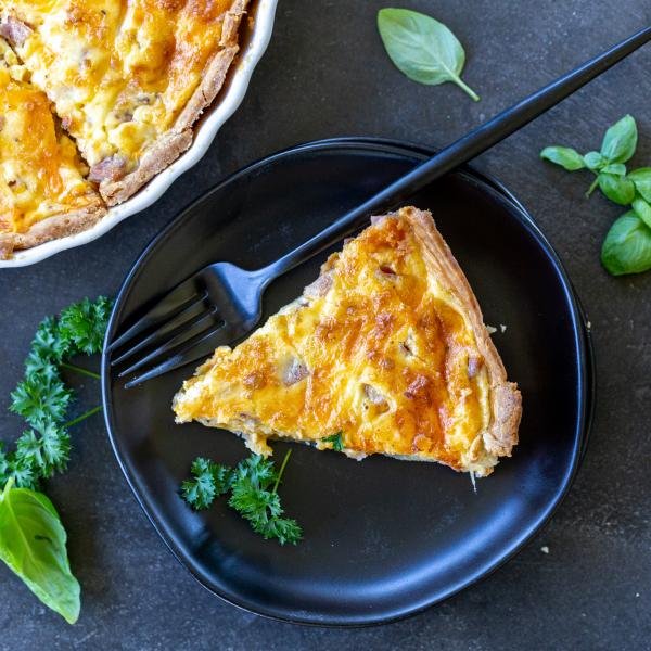 A slice Ham and Cheese Quiche in a plate.