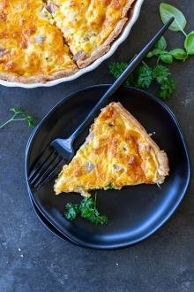 A slice Ham and Cheese Quiche in a plate.