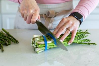 Knife cutting into asparagus.