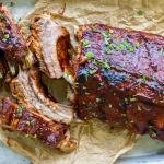 Sliced ribs on a baking pan and parchment paper.
