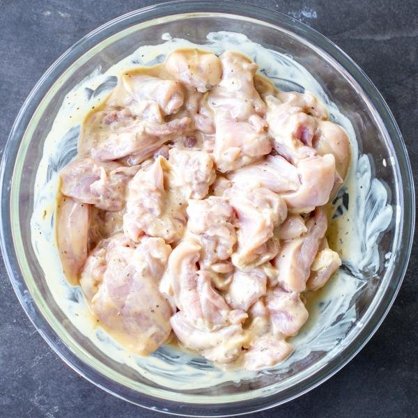 Chicken marinating in a bowl.
