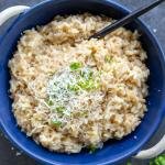 Parmesan risotto in a bowl with cheese and herbs.