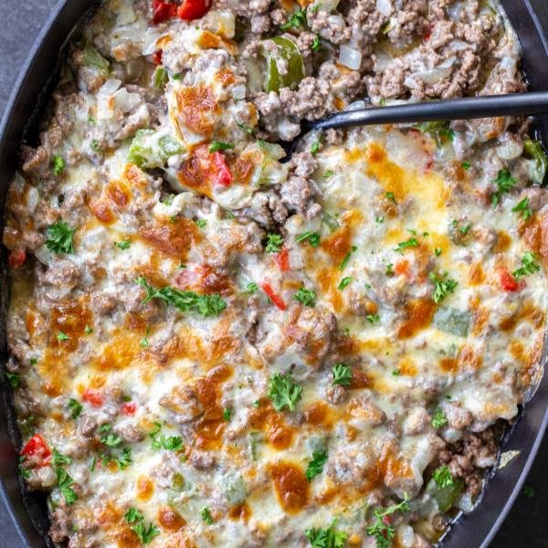 Baked Philly Cheesesteak Casserole with a spoon.