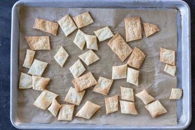 Baked sourdough crackers on on a baking sheet.
