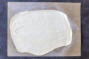 Rolled out sourdough crackers dough on parchment paper.