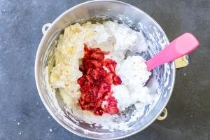Strawberries added to the English Eton Mess in a mixing bowl.