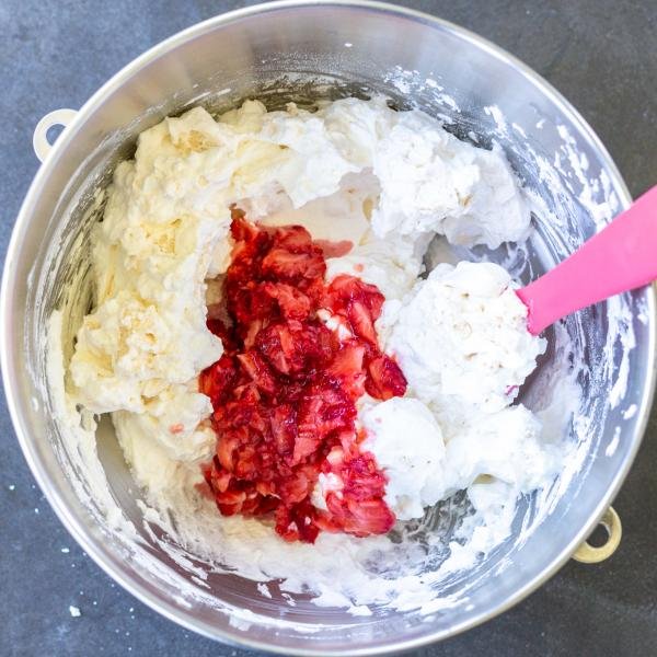 Strawberries added to the English Eton Mess in a mixing bowl.