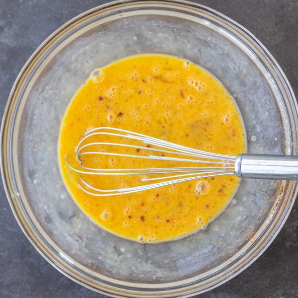 Eggs in a bowl with seasoning.