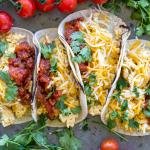 Good Egg Tacos on a tray with herbs.