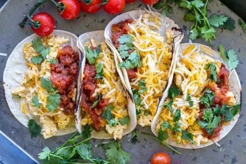 Good Egg Tacos on a tray with herbs.
