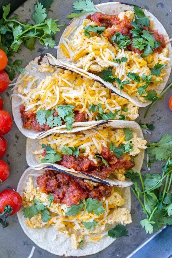 Good Egg Tacos on a tray with herbs. 