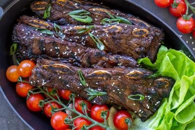 Grilled Beef Galbi on a serving tray with veggies.