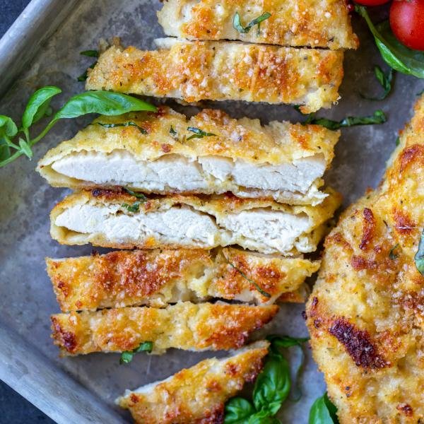 Parmesan Crusted Chicken with herbs on a tray.