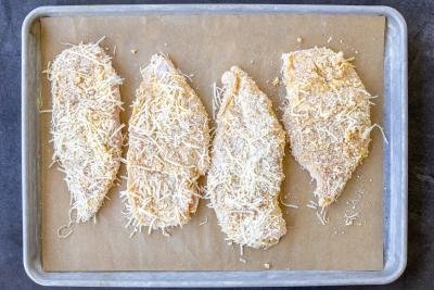 Coated chicken breast on a baking sheet.