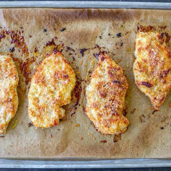 Baked chicken parmesan on a baking sheet.