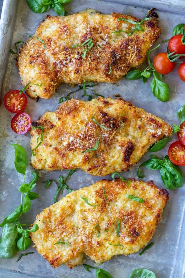 Parmesan Crusted Chicken with herbs on a tray. 