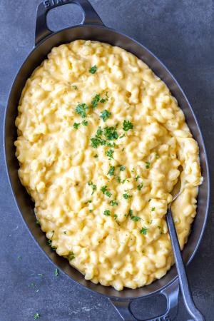 Mac and cheese in a pan with herbs on top.