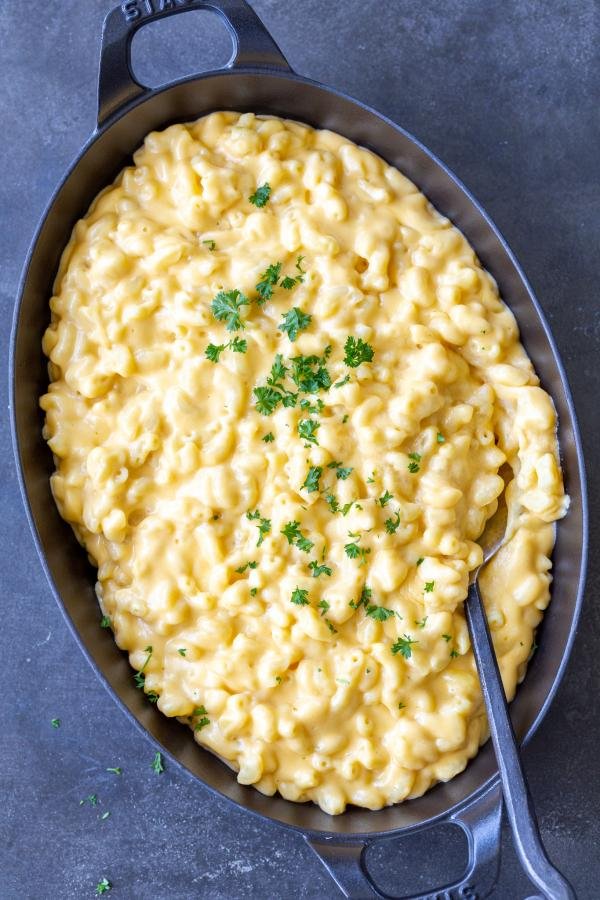 Mac and cheese in a pan with herbs on top. 