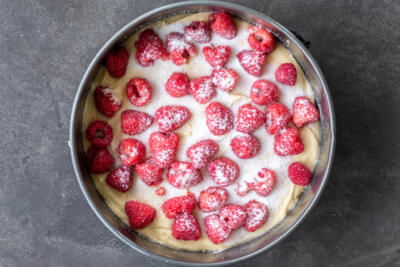Sugar on top of raspberries and cake batter.