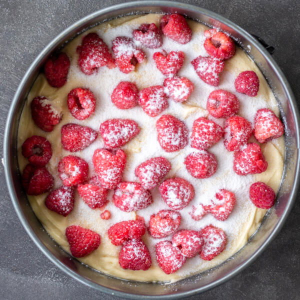 Sugar on top of raspberries and cake batter.