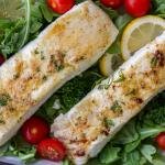 Baked Halibut on a plate with herbs and greens.