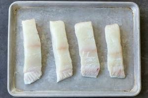Sliced halibut on a baking sheet.