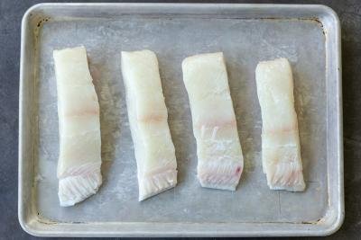 Sliced halibut on a baking sheet.