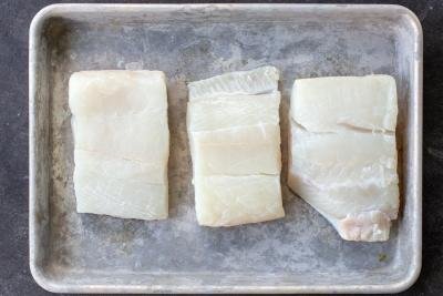 Sliced halibut on a baking pan.