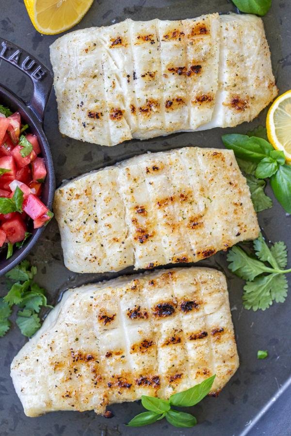 Grilled halibut on pan with pico and lemon.