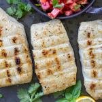 Grilled halibut on pan with pico and lemon.