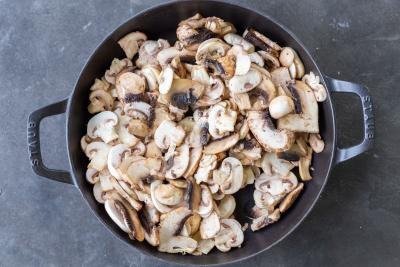 Mushrooms getting browned in a pan.