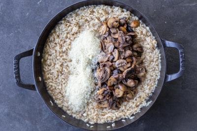 Parmesan and mushrooms added to the pan with rice.