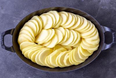 Sliced potatoes in a baking pan.
