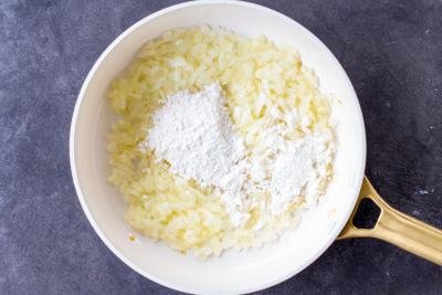 Cooked onions in a pan with flour.