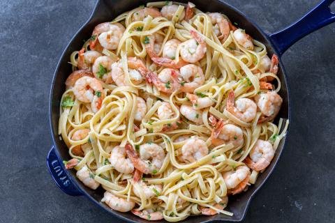 Shrimp Linguine in a pan with herbs and Parmesan.