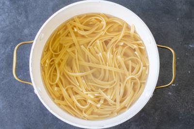 Cooked linguine in a pot with water.
